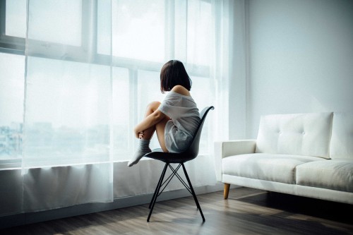 Woman sitting on a chair and looking out of the window